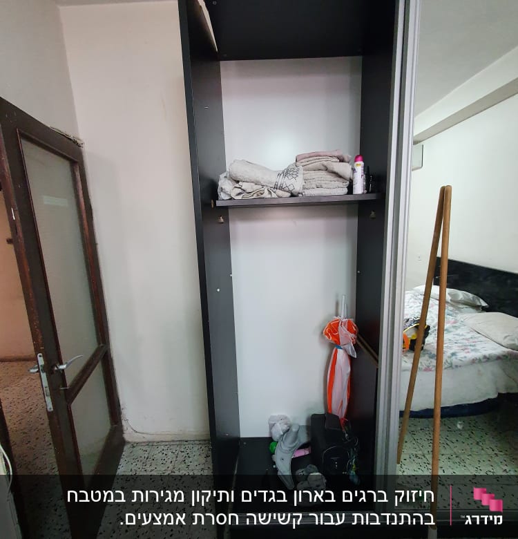 ארון פתוח עם מגבות, מטאטא וכלי עבודה שונים